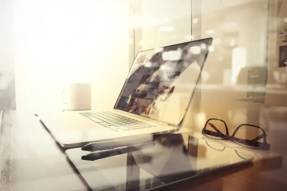 Office workplace with laptop and smart phone on wood table and london city blurred background